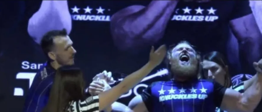 Cody Wood celebrating a win at the Knuckles Up table, arms raised