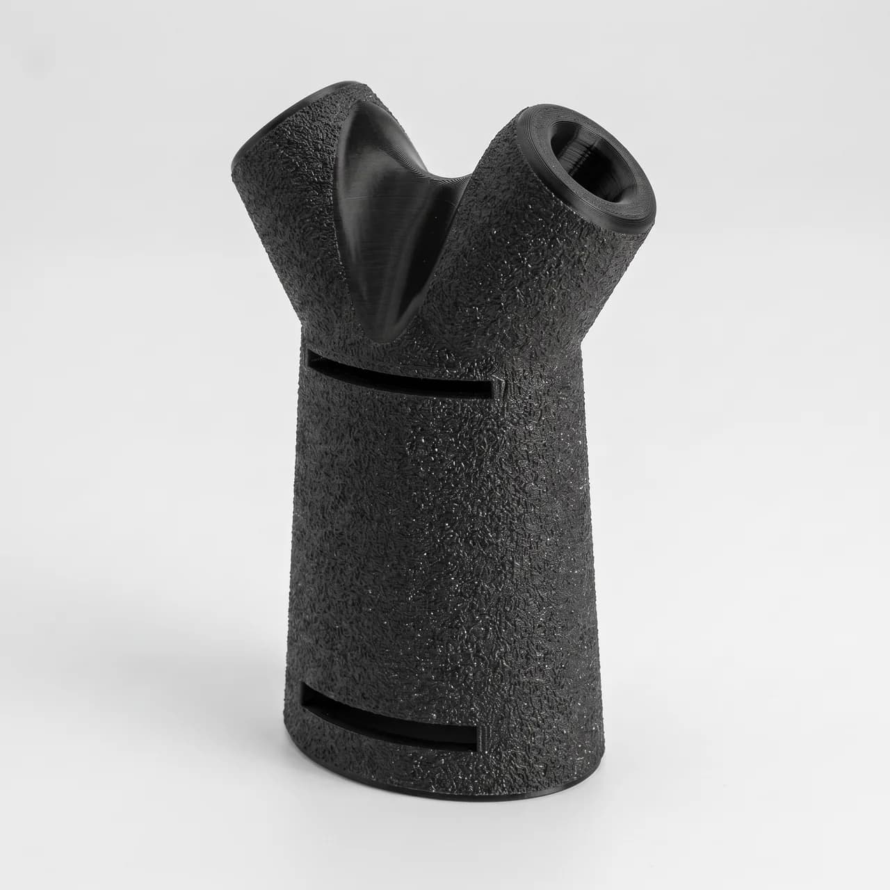 Pronatinator standing upright, low three-quarter view showing the forked top with two angled strap bores and the two body slots